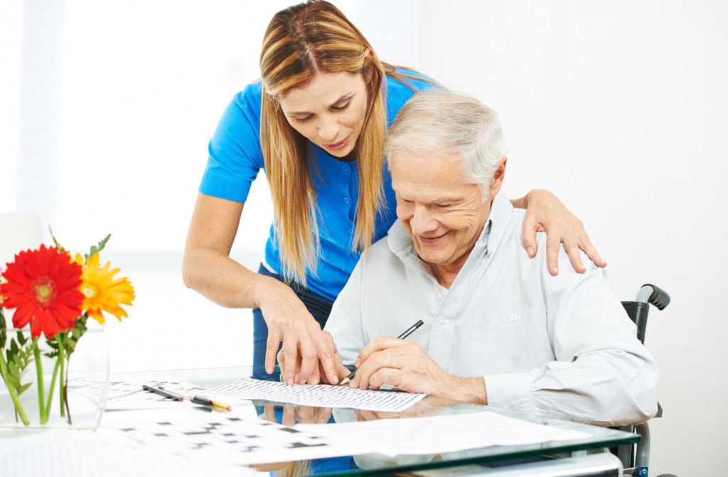 A skilled caregiver helping an elderly man struggling with memory loss.